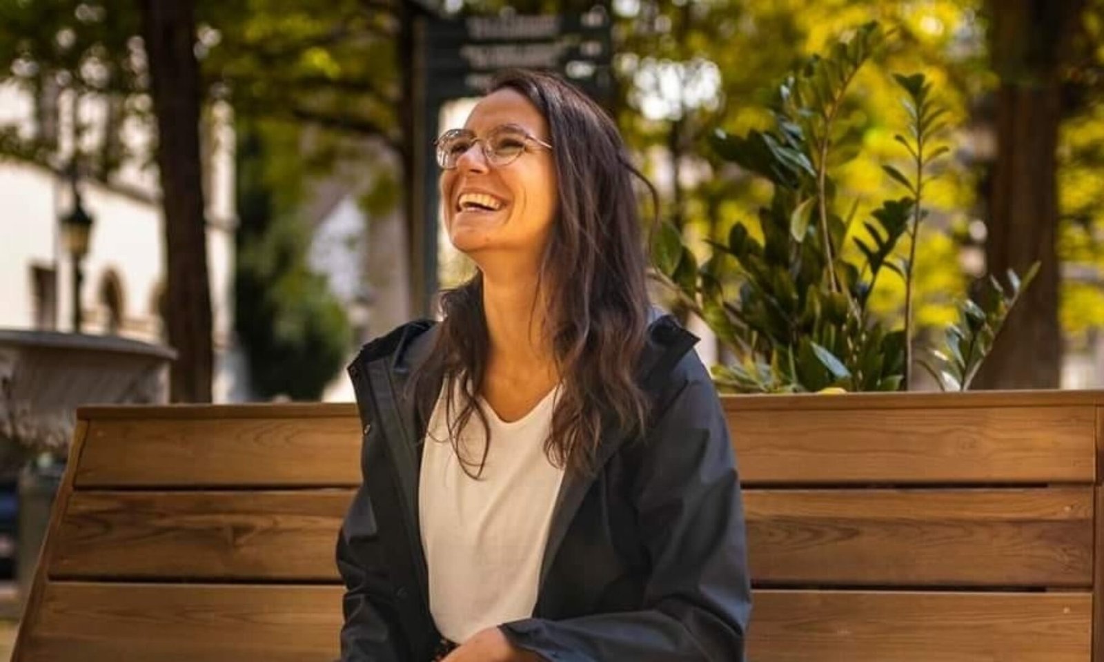 Holistic midwife specializing in prenatal and postnatal care sitting on a wooden bench in a calm and peaceful environment.